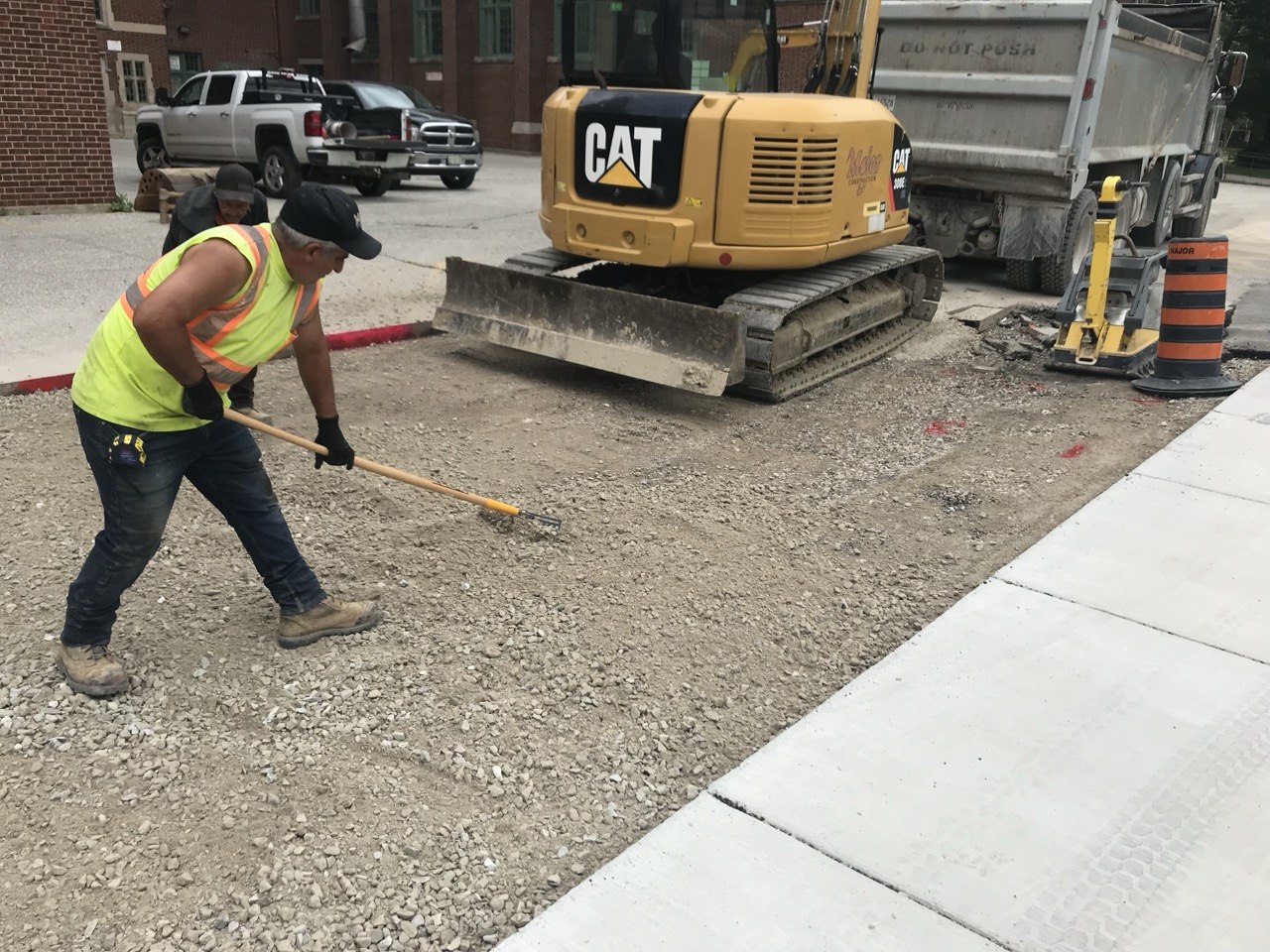 Worker with excavator grading